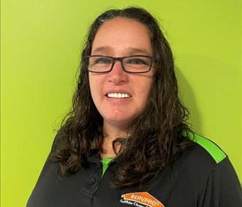 A woman standing in front of a green wall