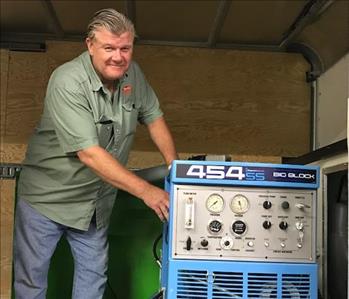 A man standing inside a truck next to equipment